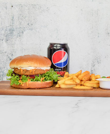 A delicious burger served with chips and can of drink at Peri Peri Pepper
